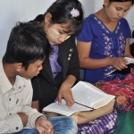 Young people in Myanmar studying the Bible with their pastor
